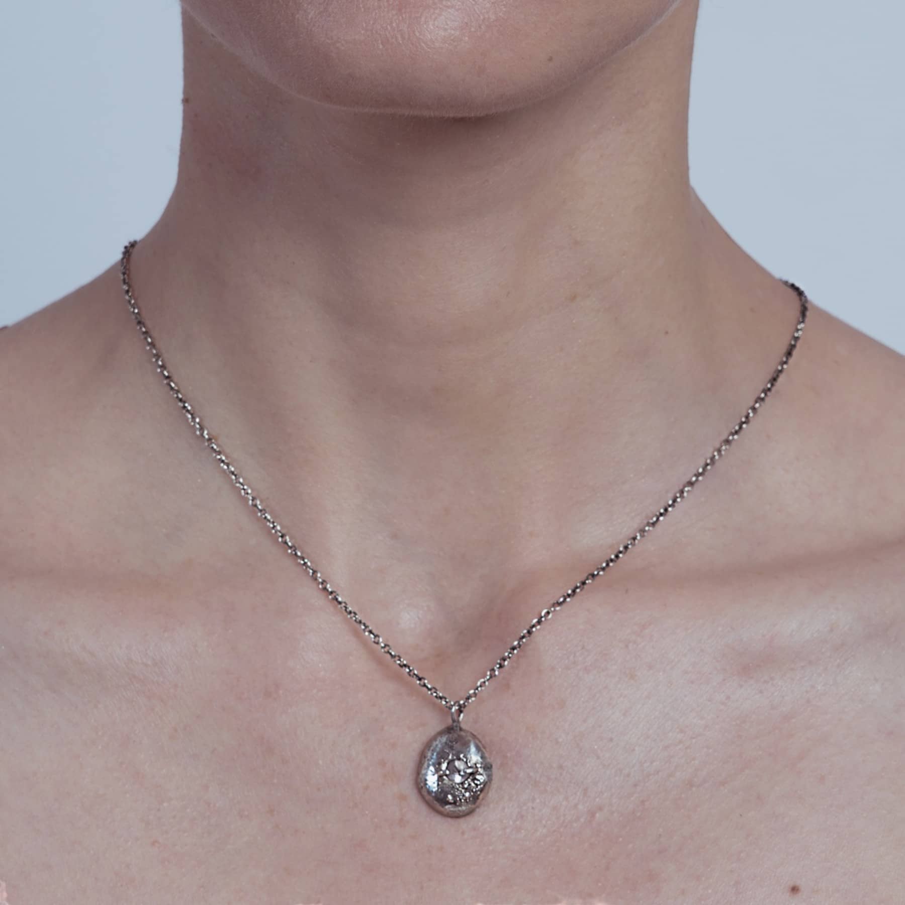aerolite pendant necklace in silver with rosa quartz, worn on neck, INNAN Jewellery Berlin