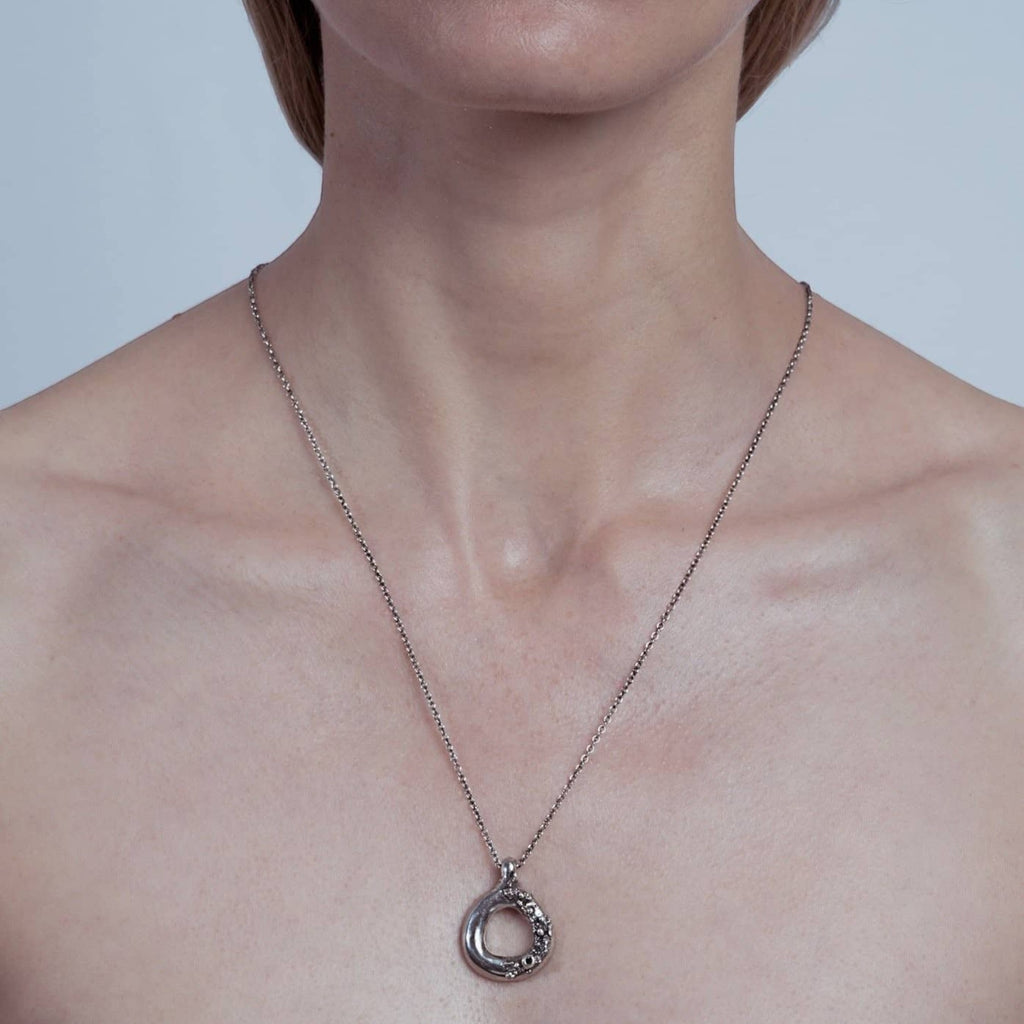 asterism pendant necklace in silver with black diamond, worn on neck, INNAN Jewellery Berlin