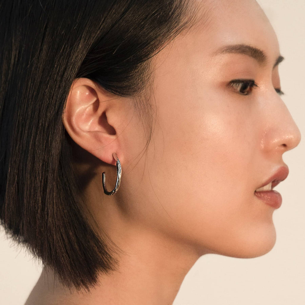 cenote hoop earrings in silver, worn on ear, INNAN Jewellery Berlin