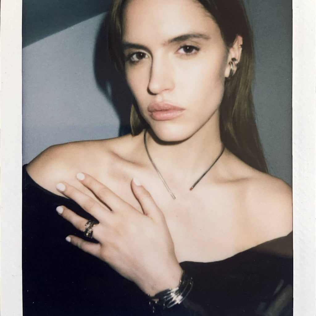 Model wearing the Chaotic Curve necklace in silver with black diamond, styled with other INNAN Jewellery pieces, polaroid-style image, INNAN Jewellery Berlin