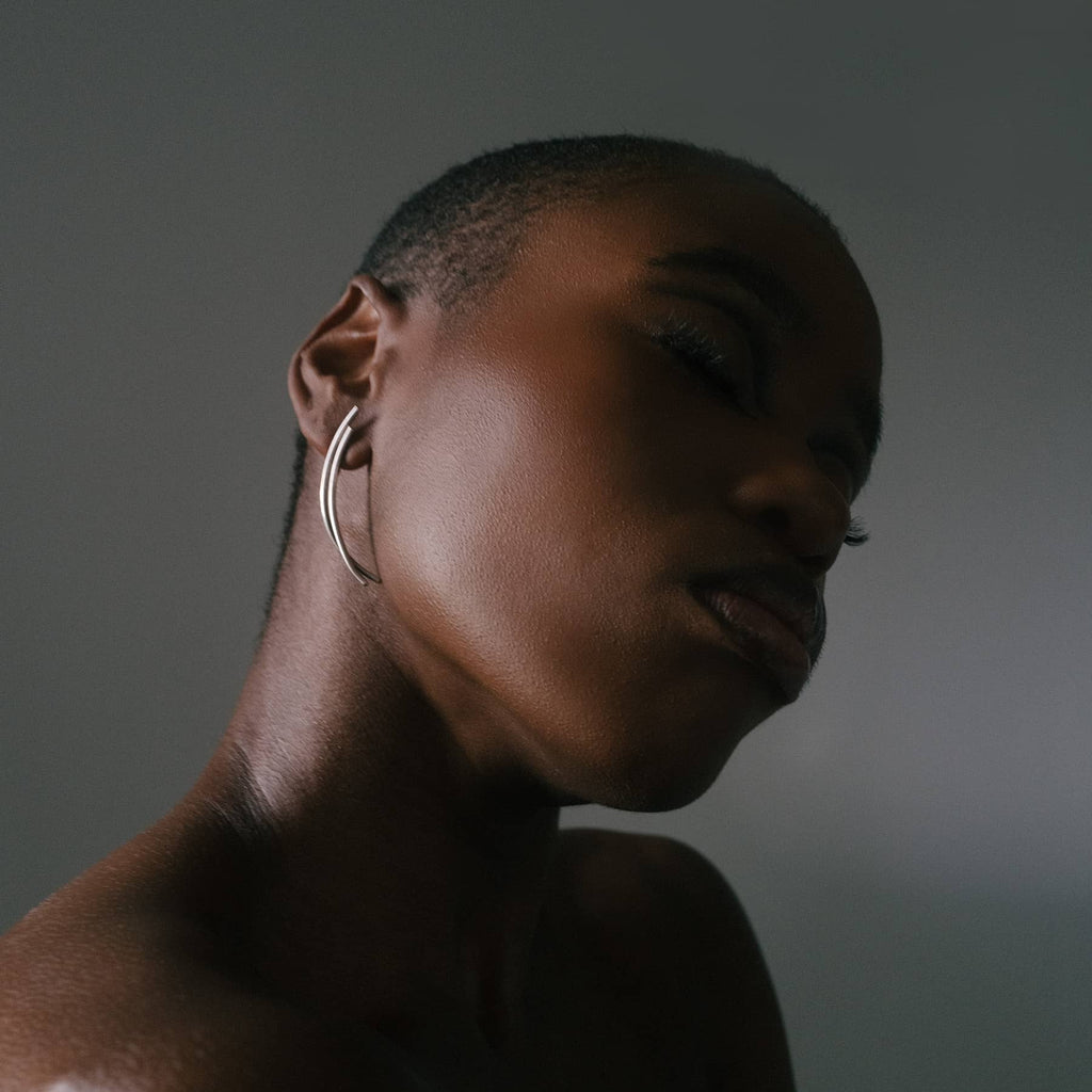 chaotic dawn earrings in silver, worn on ear in close-up, INNAN Jewellery Berlin
