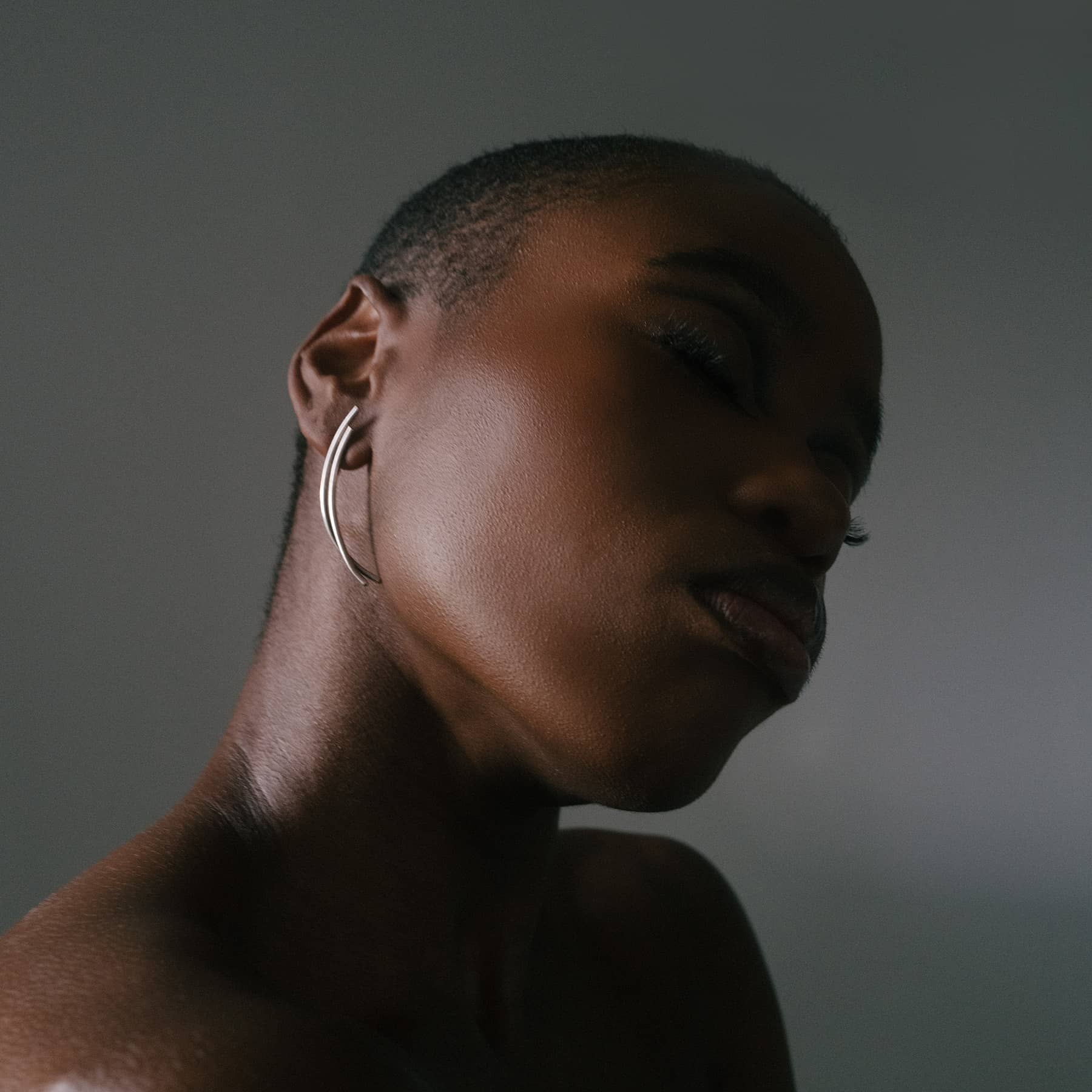 chaotic dawn earrings in silver, worn on ear in close-up, INNAN Jewellery Berlin
