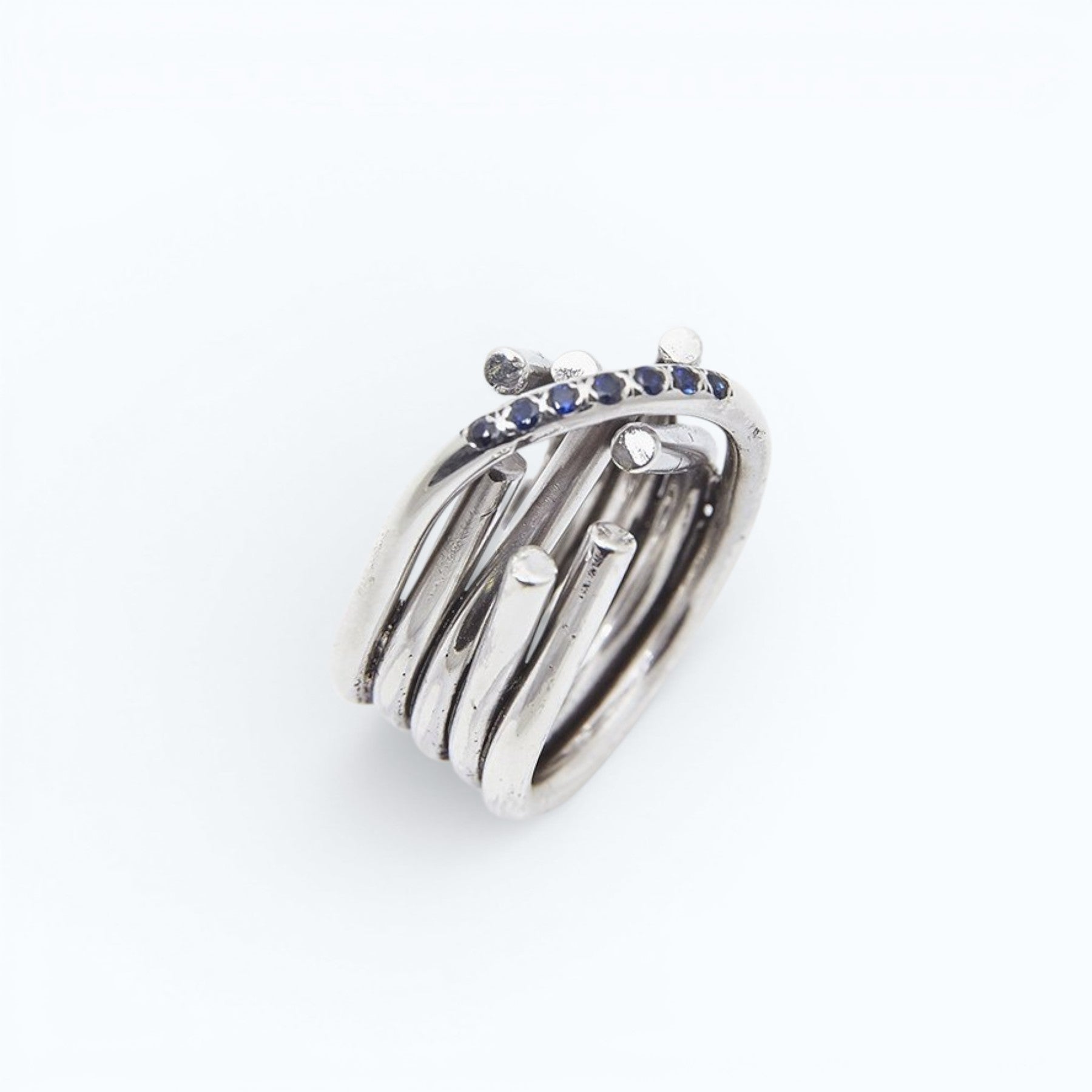 chaotic infinity ring in silver with yellow and blue sapphires, close up worn on a hand, INNAN Jewellery Berlin