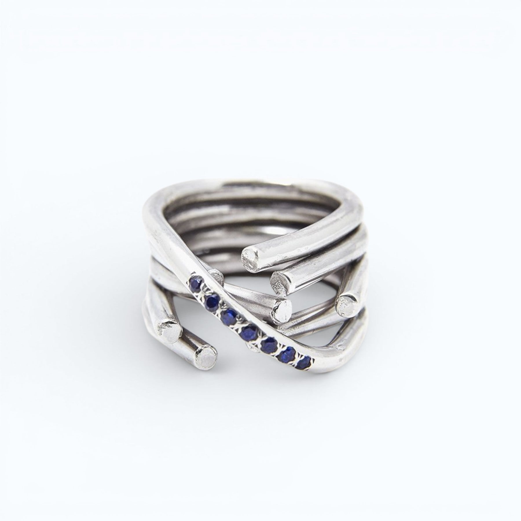 chaotic infinity ring in silver with yellow and blue sapphires, close up worn on a hand, INNAN Jewellery Berlin