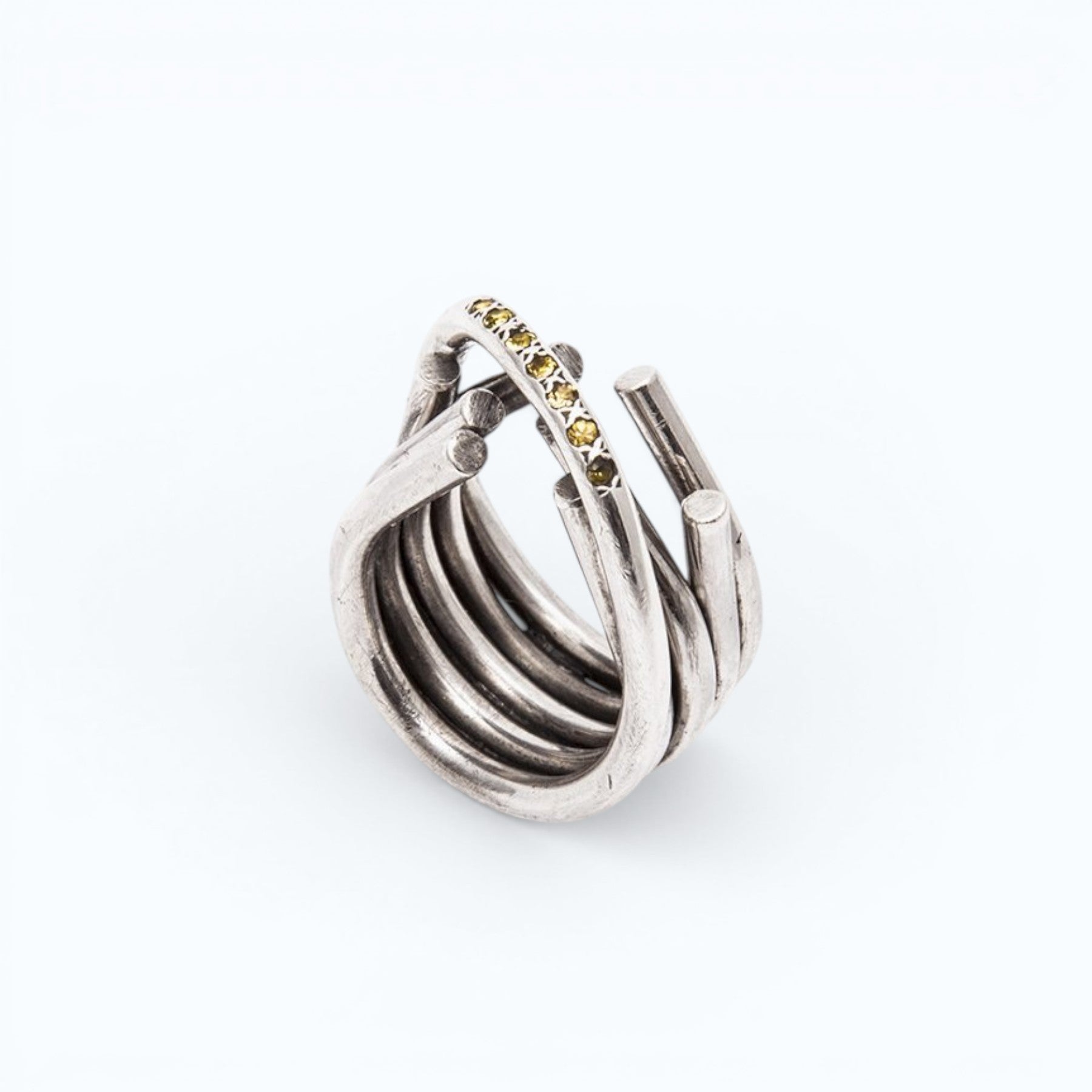 chaotic infinity ring in silver with yellow and blue sapphires, close up worn on a hand, INNAN Jewellery Berlin