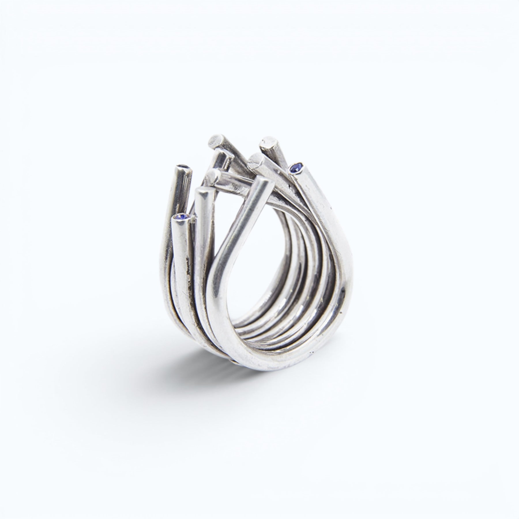 chaotic petite infinity ring in silver with blue sapphires, product image shot on artistic background of a sky reflection, INNAN Jewellery Berlin