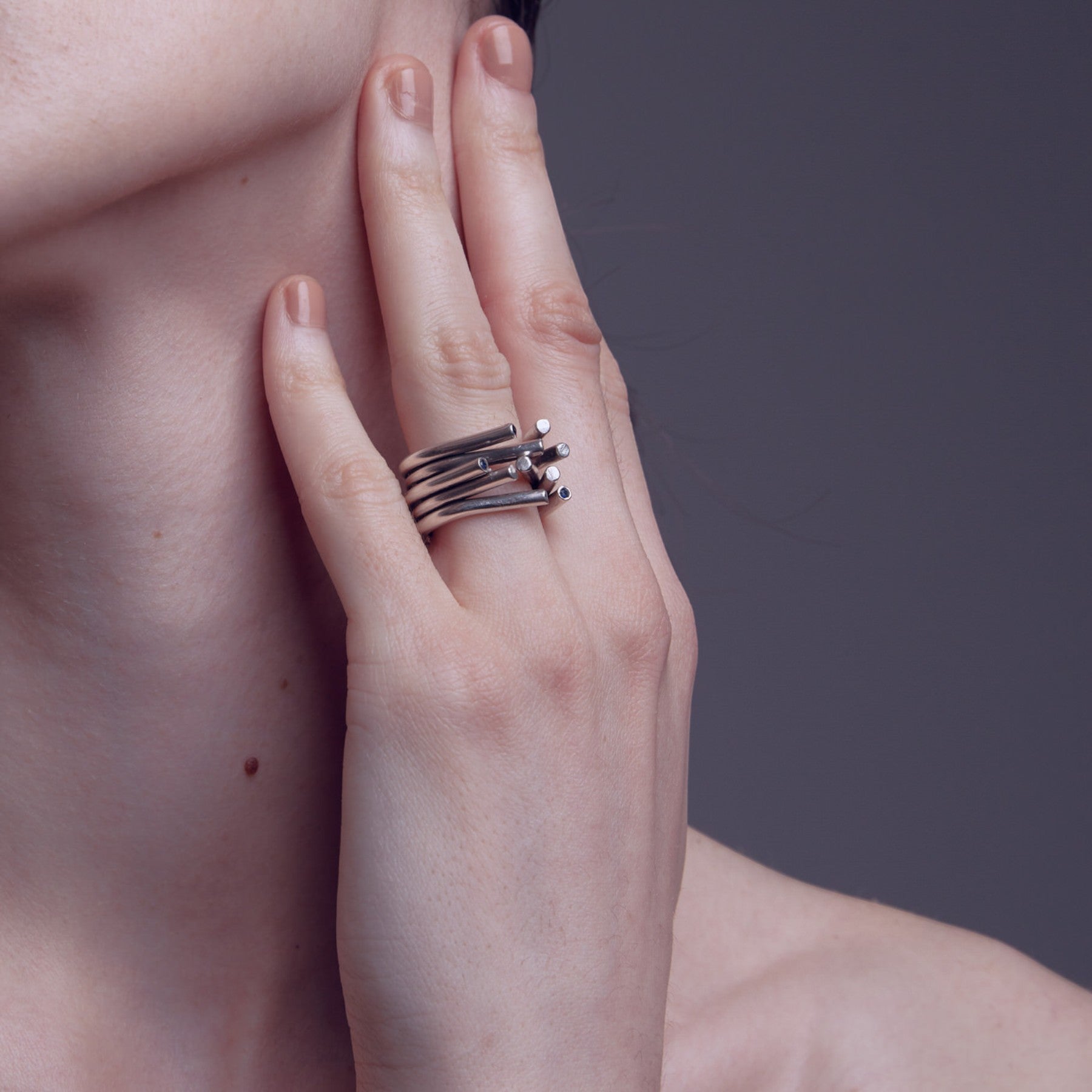 chaotic petite infinity ring in silver with blue sapphires, product image shot on artistic background of a sky reflection, INNAN Jewellery Berlin
