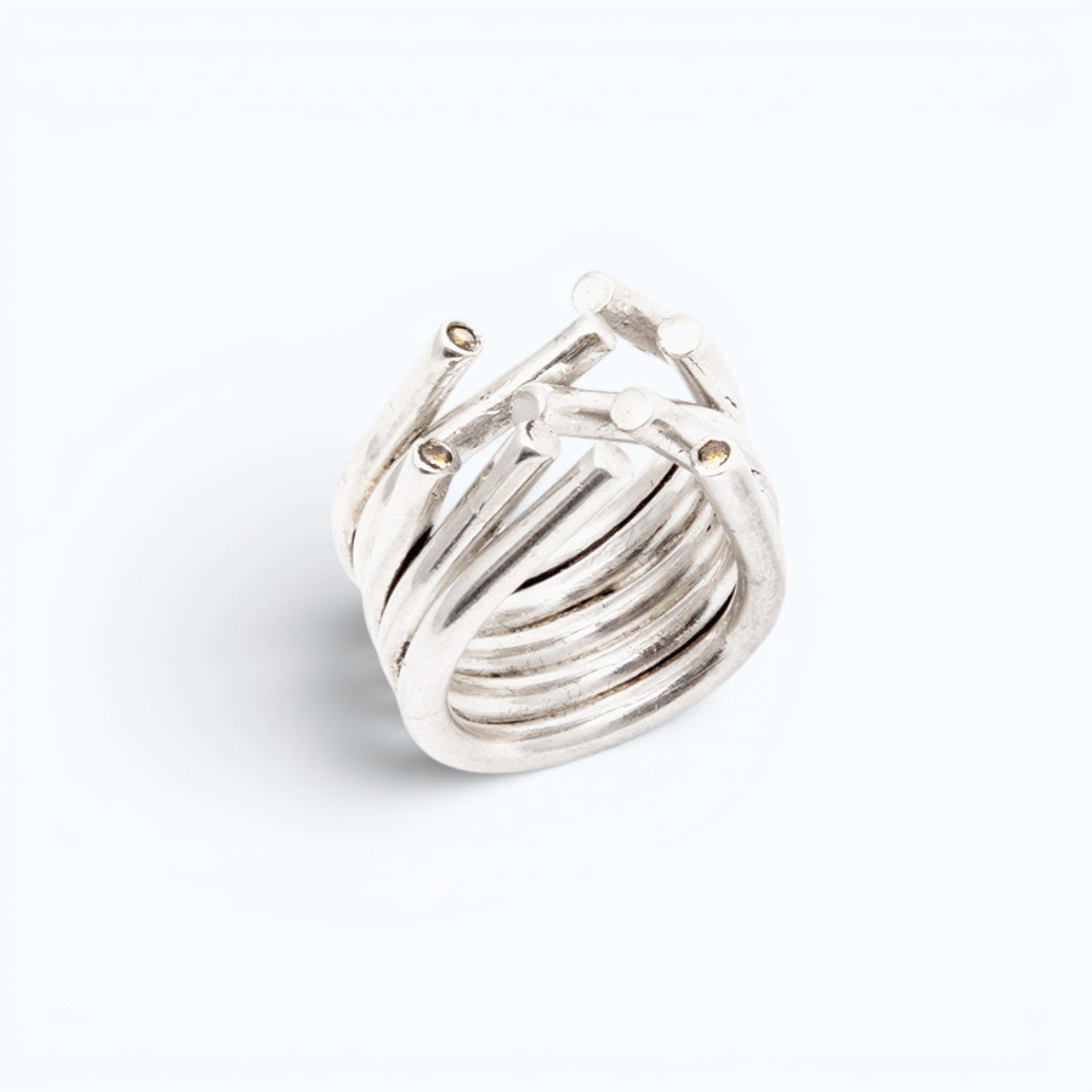 chaotic petite infinity ring in silver with blue sapphires, product image shot on artistic background of a sky reflection, INNAN Jewellery Berlin