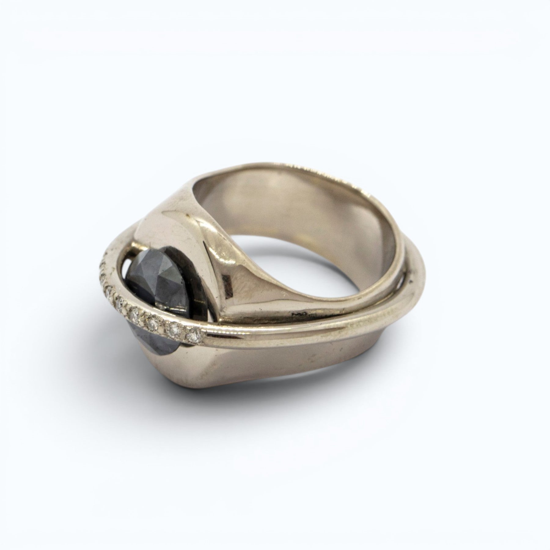 chaotic signet ring in 18 ct white gold with 2.52 ct dark indigo diamond and 9 champagne diamonds, product image with artistic background, INNAN Jewellery Berlin