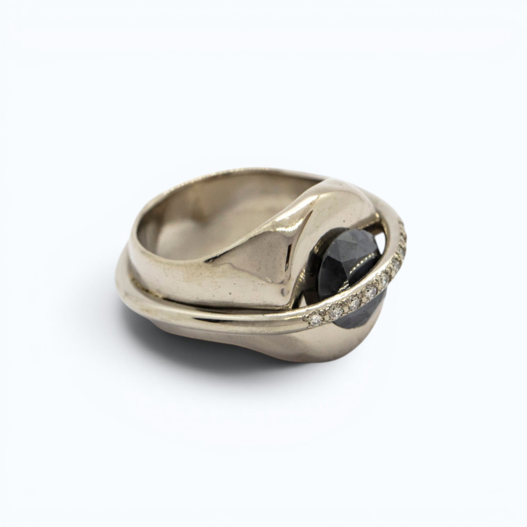 chaotic signet ring in 18 ct white gold with 2.52 ct dark indigo diamond and 9 champagne diamonds, product image with artistic background, INNAN Jewellery Berlin