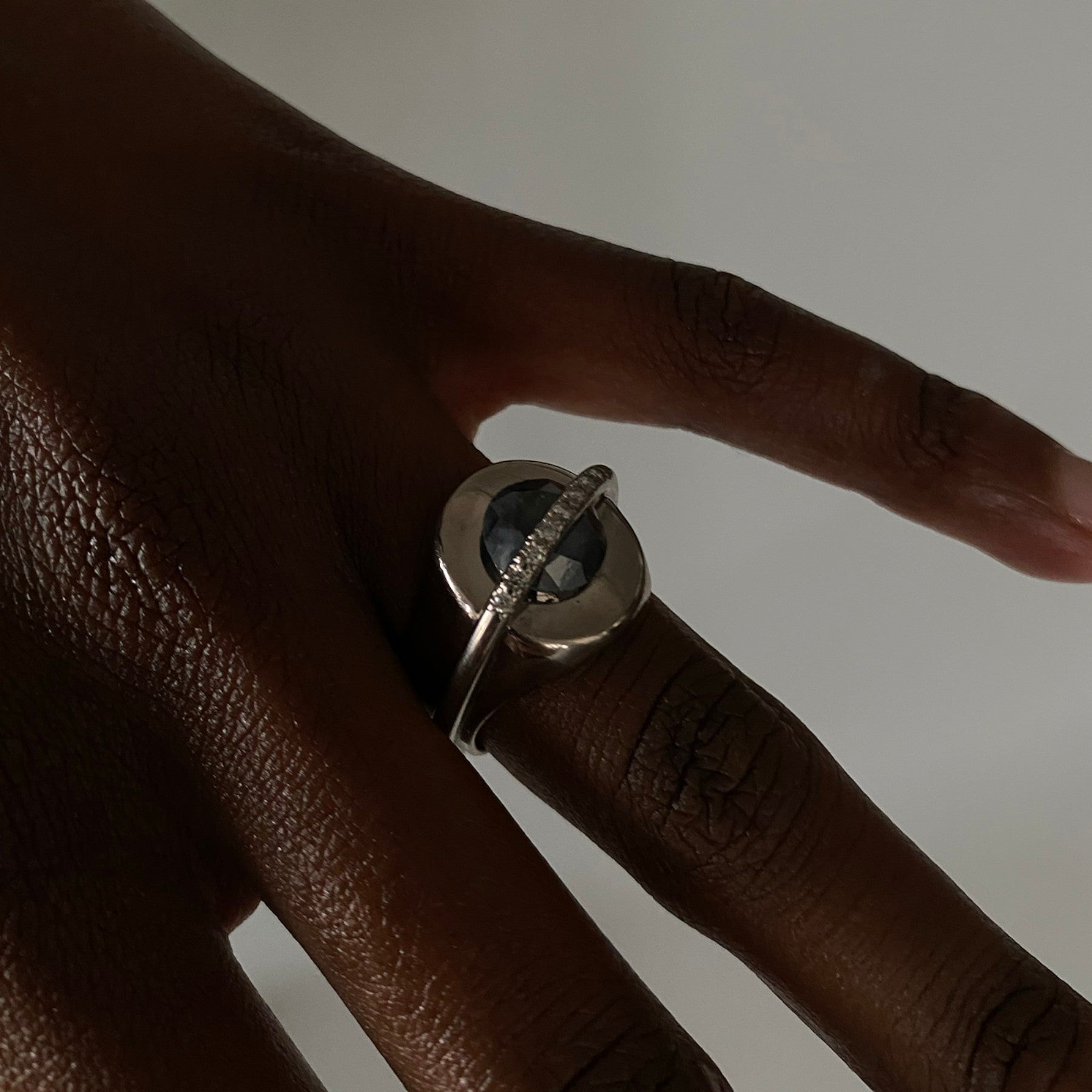 chaotic signet ring in 18 ct white gold with 2.52 ct dark indigo diamond and 9 champagne diamonds, worn, INNAN Jewellery Berlin