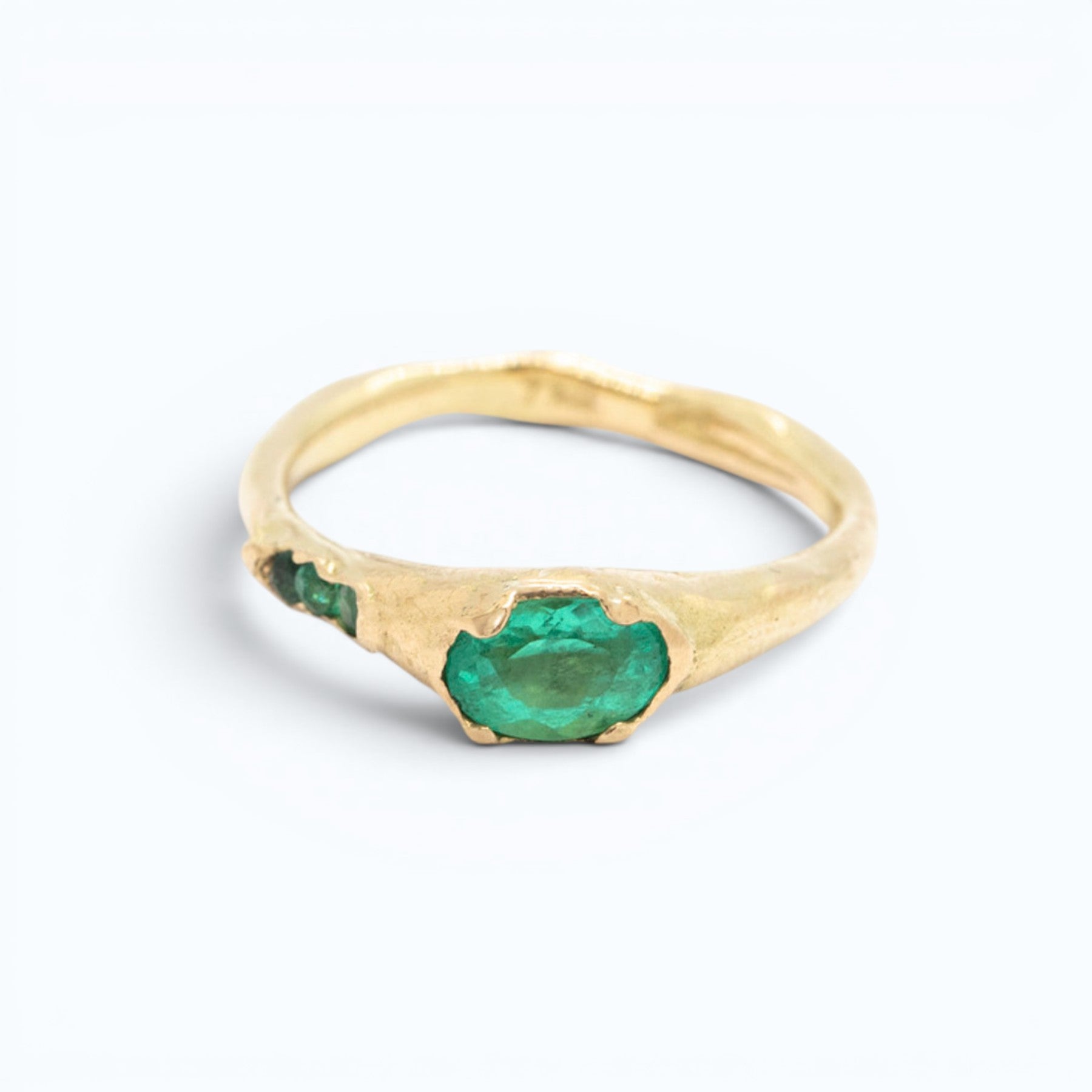 gaer engagement ring in 18 ct yellow gold with 0.5 ct natural oval-cut emerald and 3 small matching emeralds on the side, product image, INNAN Jewellery Berlin