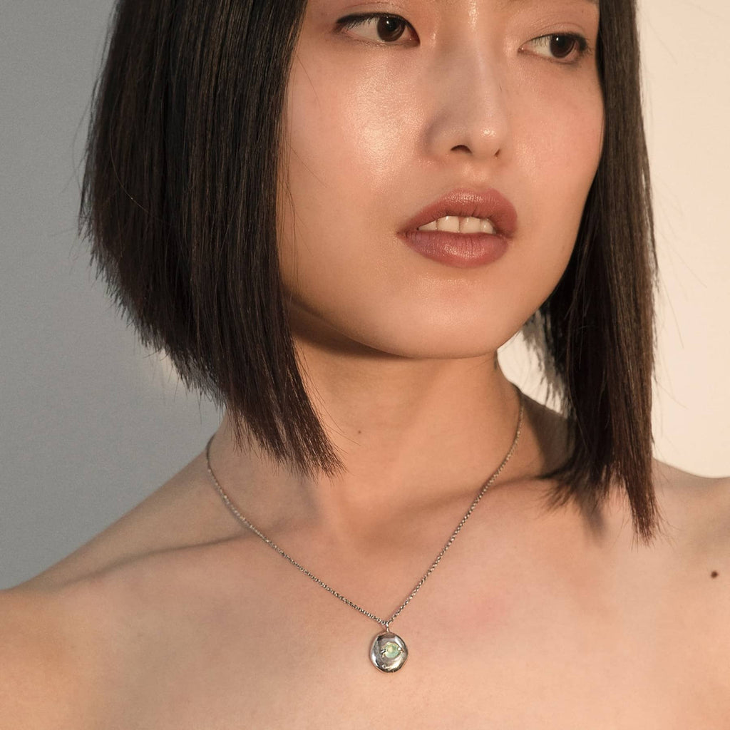 lagoon pendant necklace in silver with blue chalcedony, worn on neck, INNAN Jewellery Berlin