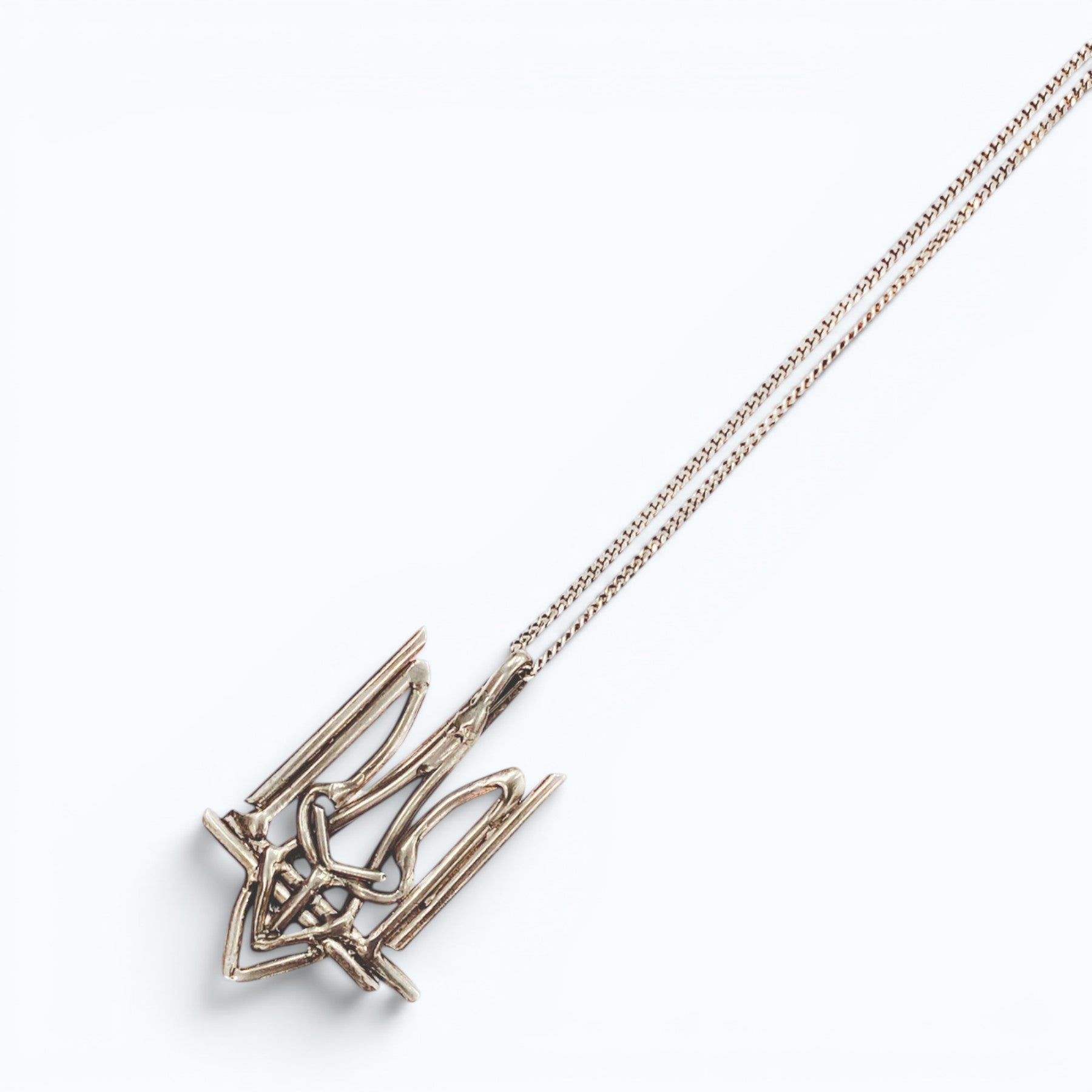 Ukrainian Trident (Tryzub) pendant necklace in silver, product image on artistic background, INNAN Jewellery Berlin