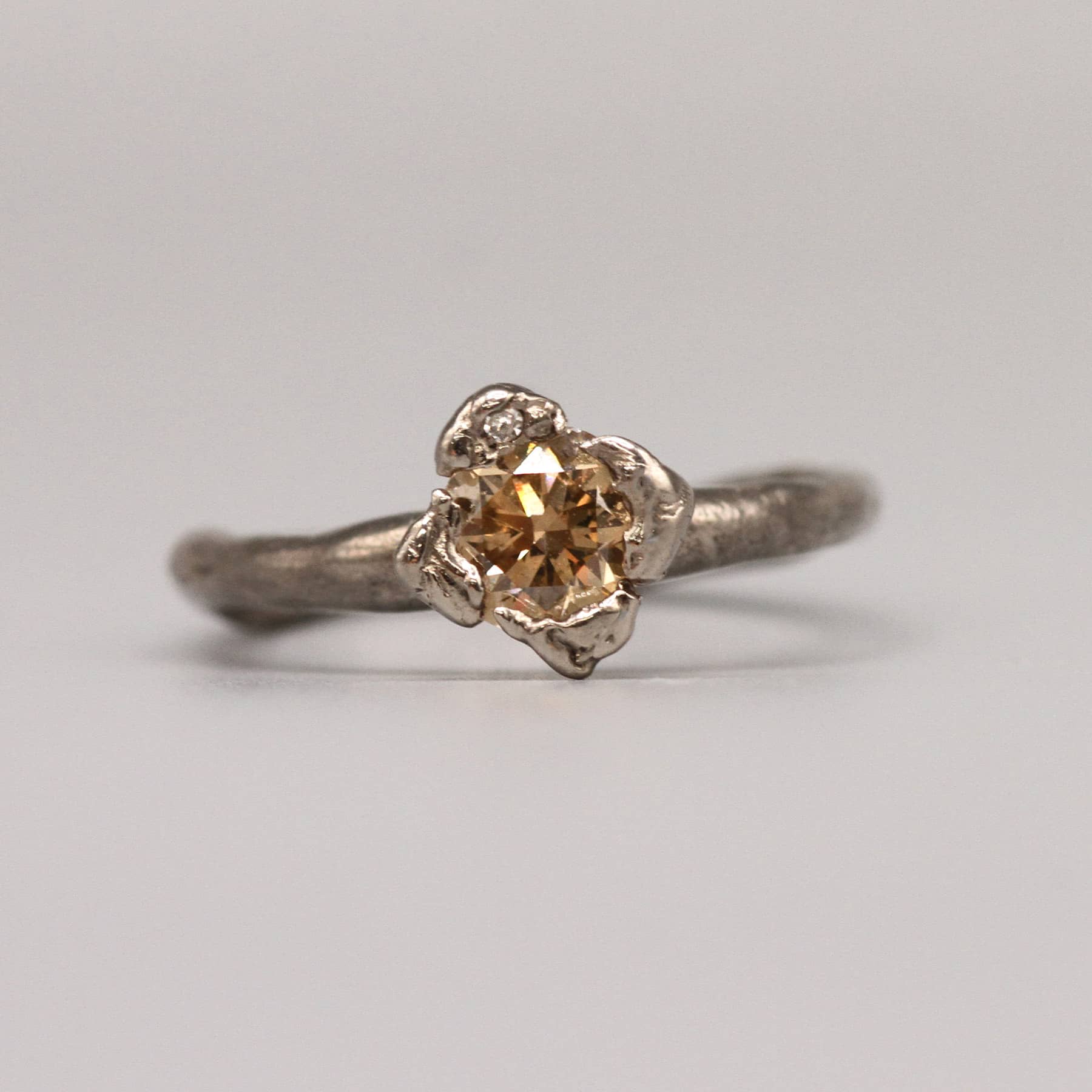 Front view of Anish engagement ring in 18 ct white gold with a 0.71 ct champagne diamond and a white diamond detail by Innan Jewellery