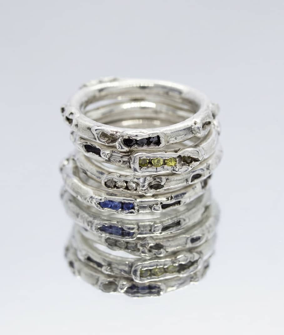 close up of the antre rings stack in silver with black and champagne diamonds as well as yellow and blue sapphires, representing the antre collection, INNAN Jewellery Berlin