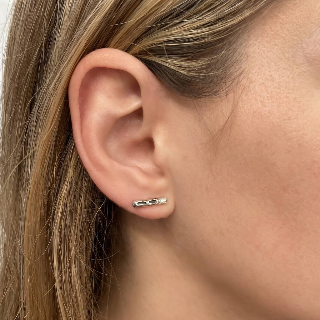 cenote bar earrings in silver, worn on ear in close-up, INNAN Jewellery Berlin
