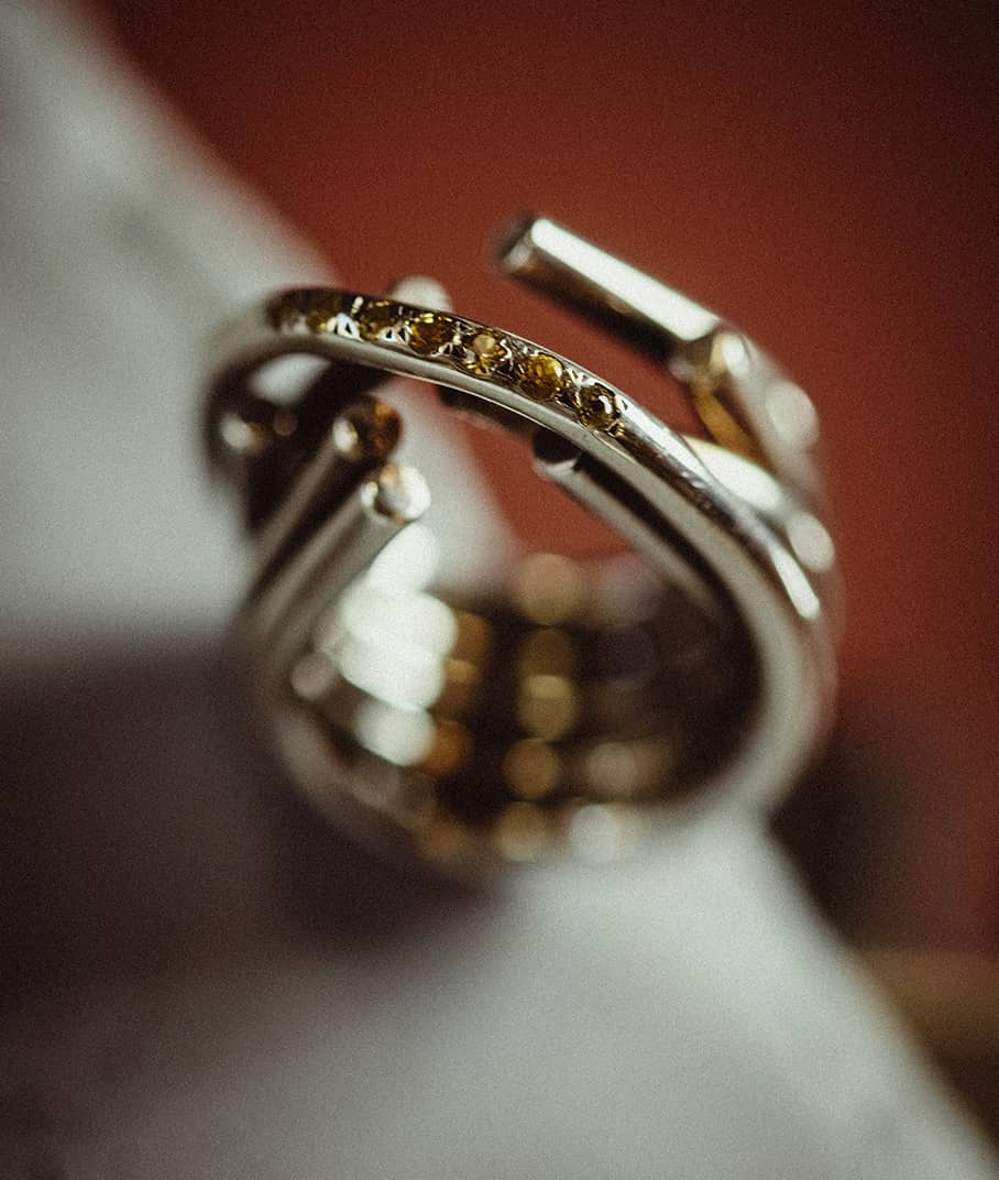 close-up of Chaotic Infinity ring in silver with yellow sapphires, representing the Chaotic collection, INNAN Jewellery Berlin