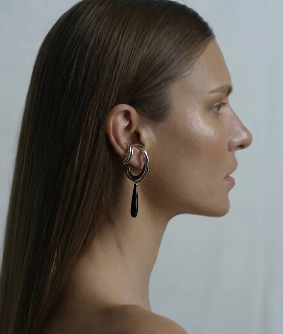 Close up of a model wearing Flow Ear cuff and Linn Drop Earrings in silver representing the FLow collection, INNAN Jewellery Berlin