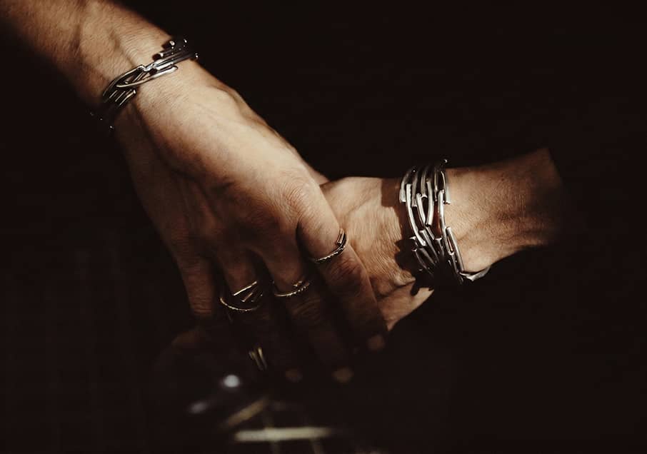 Hands wearing the Flow and the Petite Flow bracelets in silver representing the Flow collection, INNAN Jewellery Berlin
