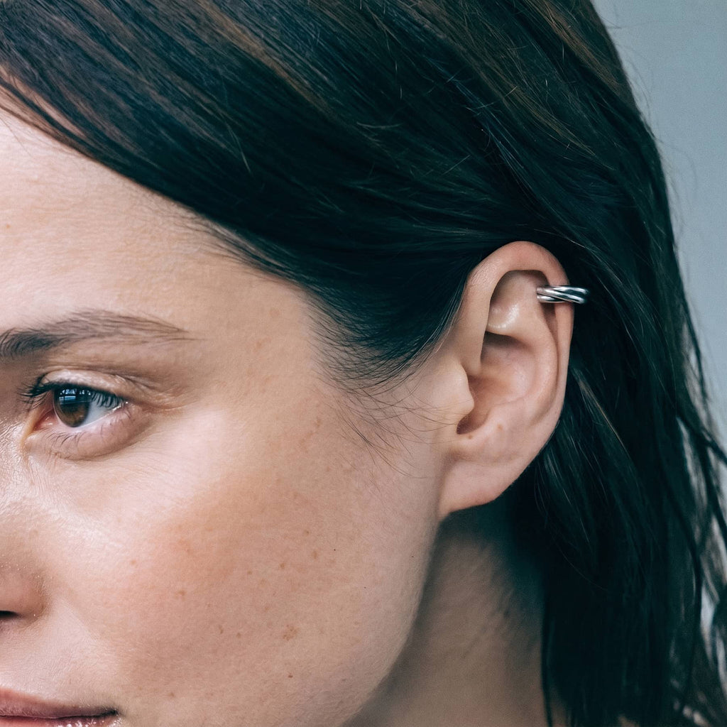 silver flow mini ear cuff, worn on ear in close-up, INNAN Jewellery Berlin