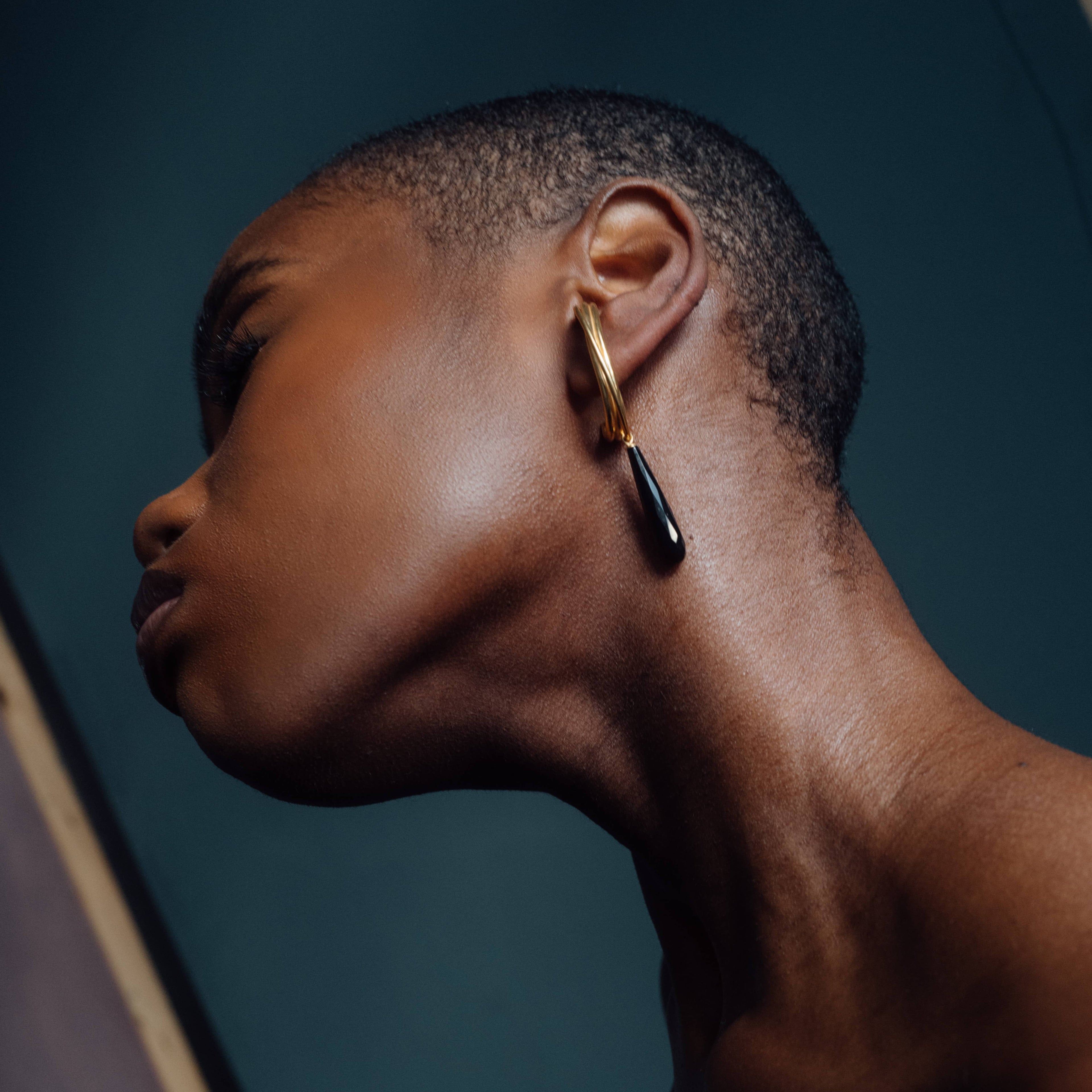 golden linn drop earrings in goldplated silver with black onyx drops, worn on ear, INNAN Jewellery Berlin