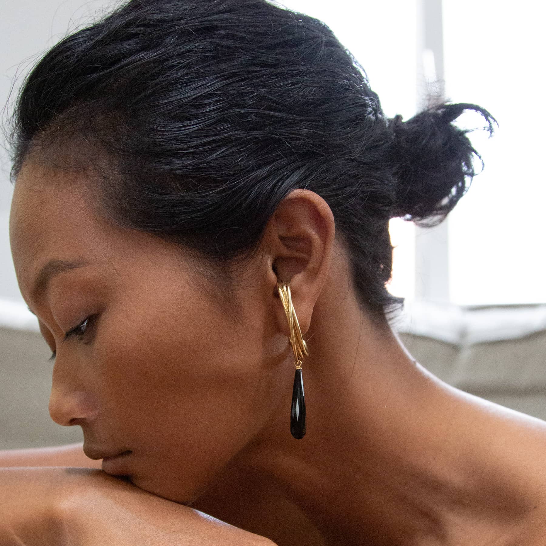 golden linn drop earrings in goldplated silver with black onyx drops, worn on ear, INNAN Jewellery Berlin