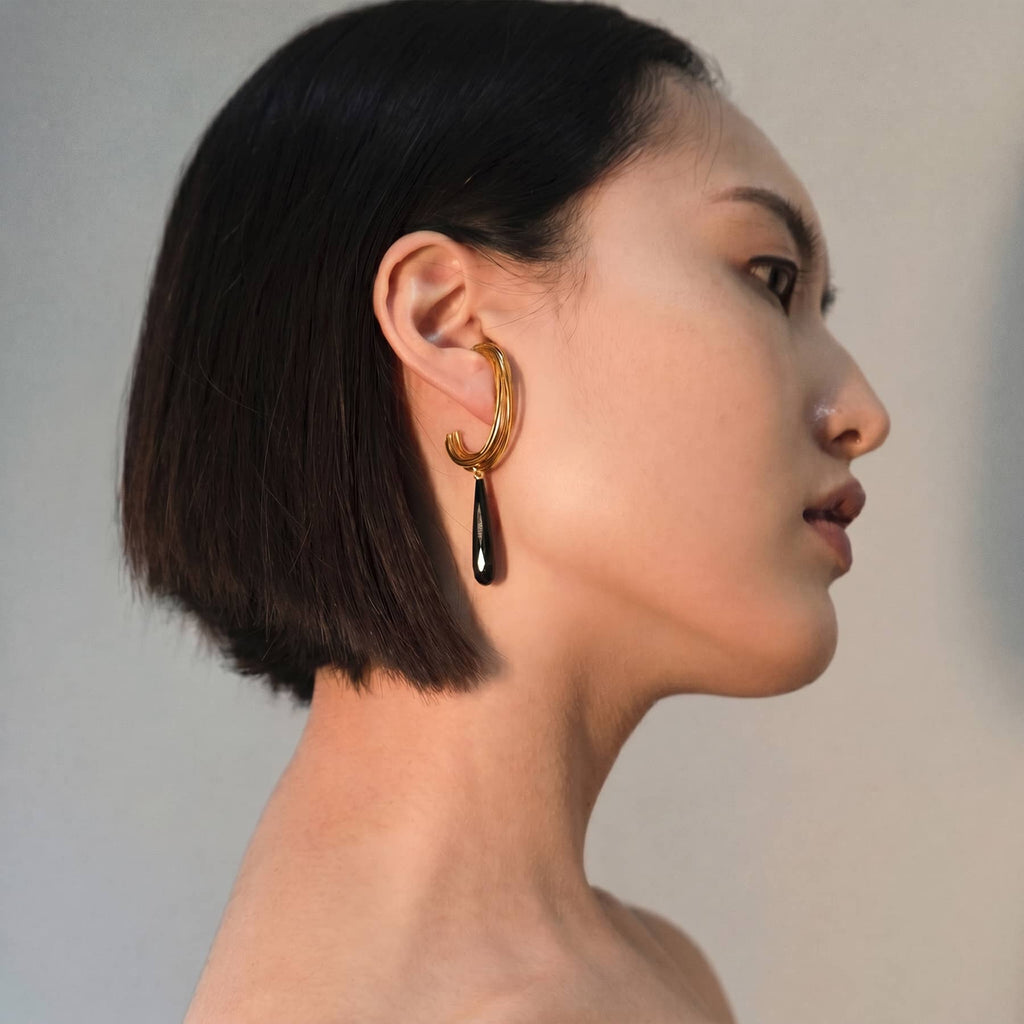 golden linn drop earrings in goldplated silver with black onyx drops, worn on ear, INNAN Jewellery Berlin
