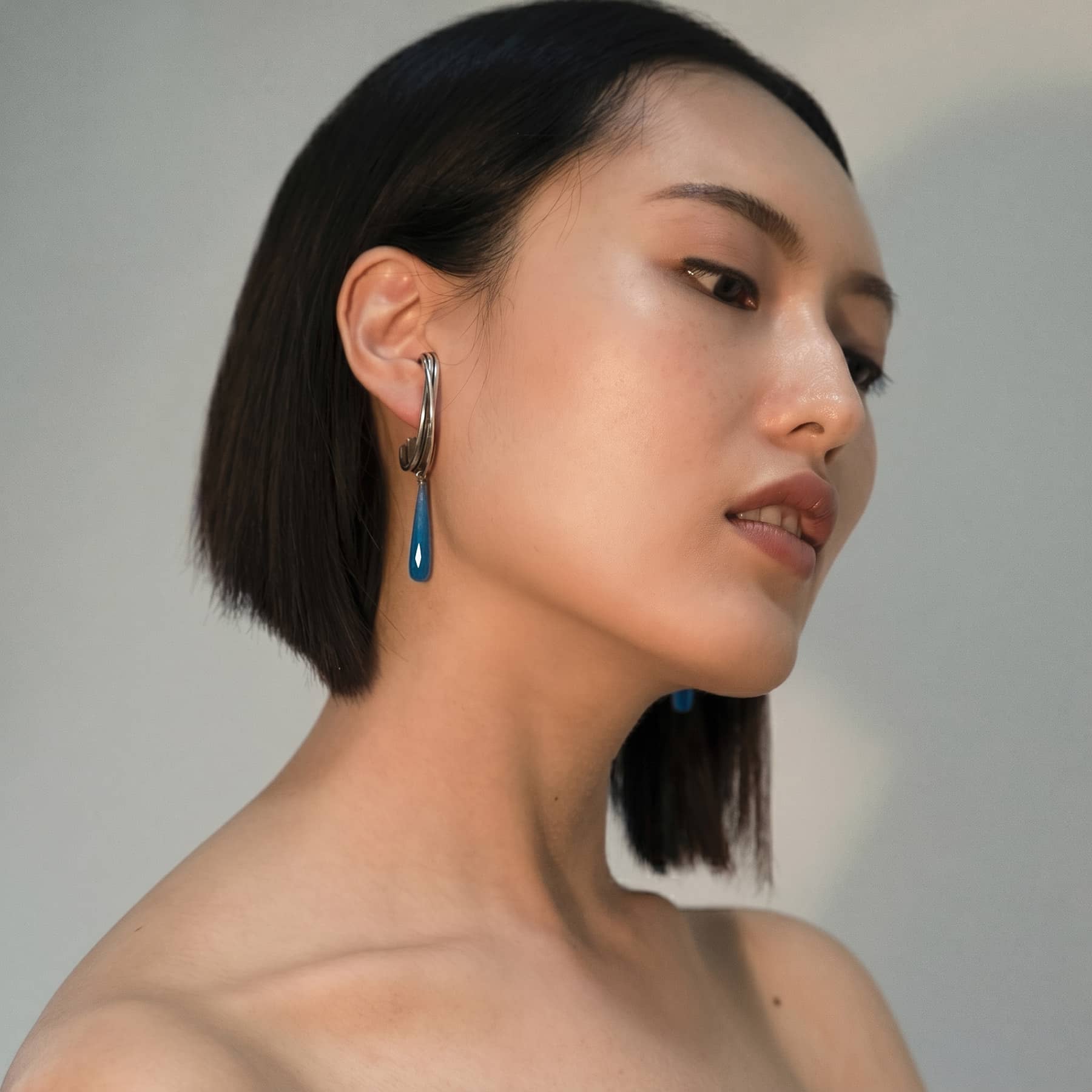 linn blue drop earrings in silver with blue agate drops, worn on ear, INNAN Jewellery Berlin