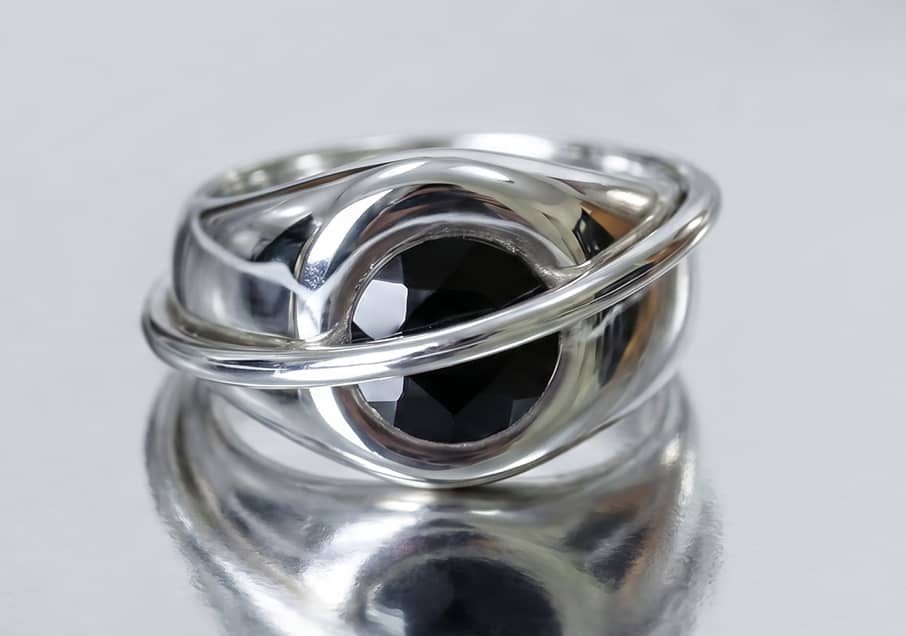 A closeup of a Chaotic Signet ring in silver with black diamond representing the Mens edit collection, INNAN Jewellery Berlin