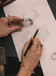Hand sketching a bracelet at the atelier workbench, illustrating the design process at Innan Jewellery