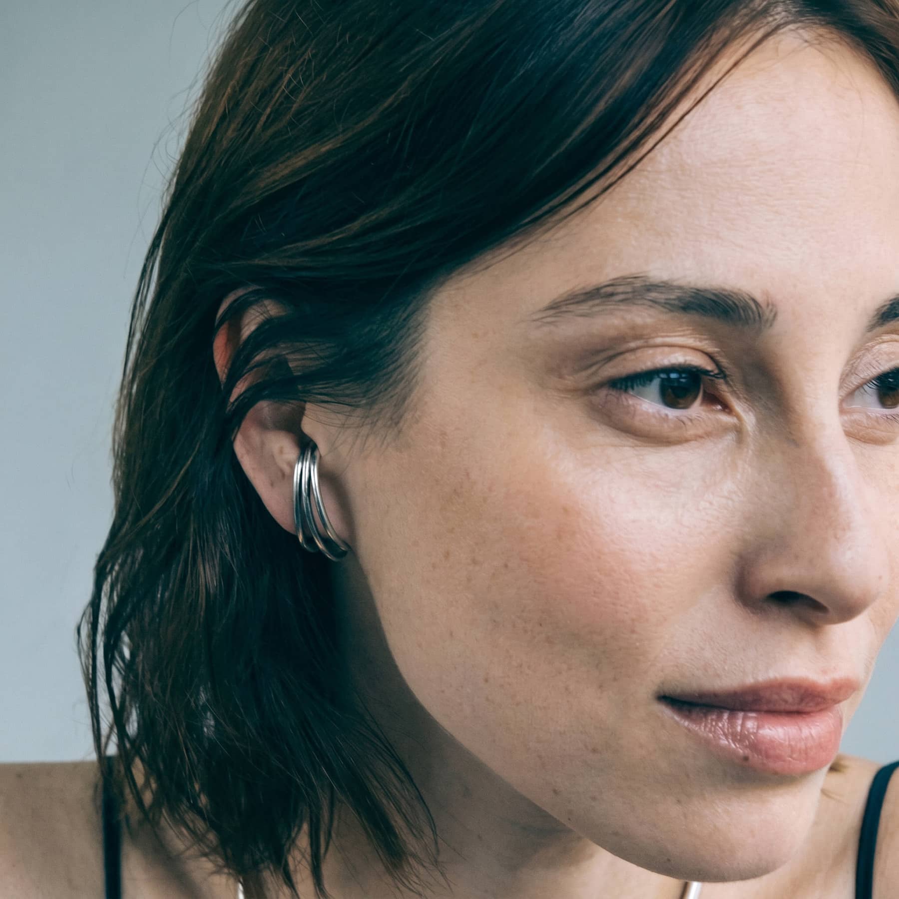 trio silver earrings, worn on ear in close-up, INNAN Jewellery Berlin
