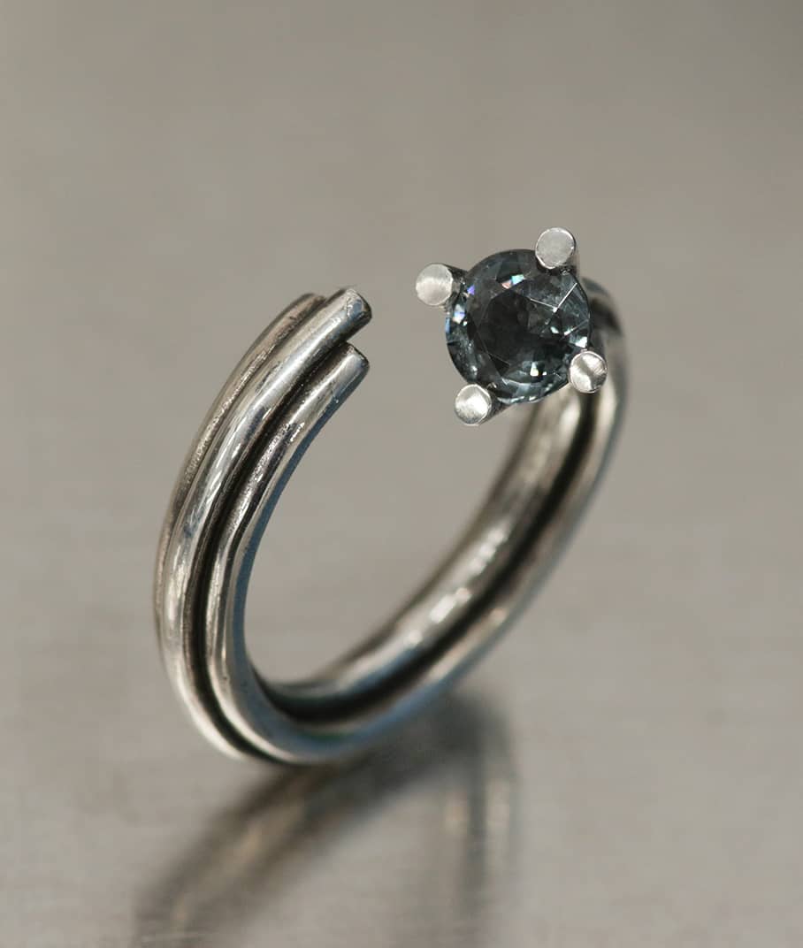 A closeup of a Vortex ring in silver with grey Spinel, representing the Vortex collection, INNAN Jewellery Berlin 