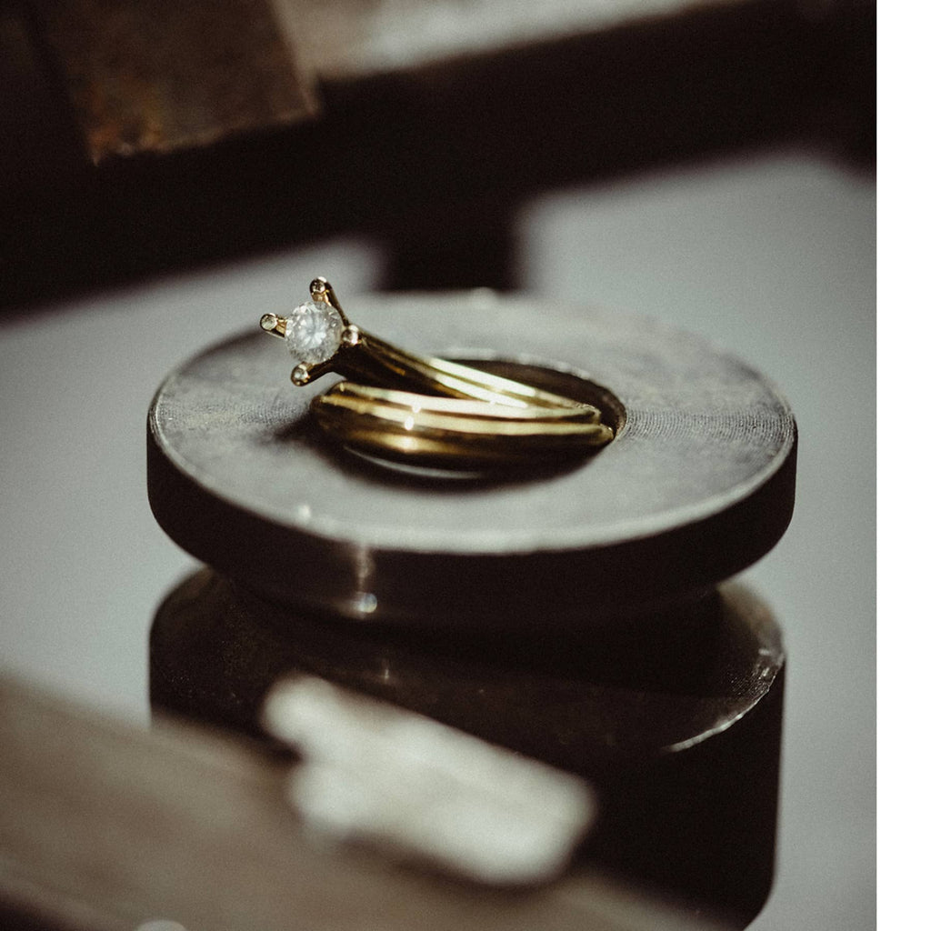 vortex ring in 18 ct yellow gld with 0.43 ct opalescent white diamond, product image with artistic background, INNAN Jewellery Berlin